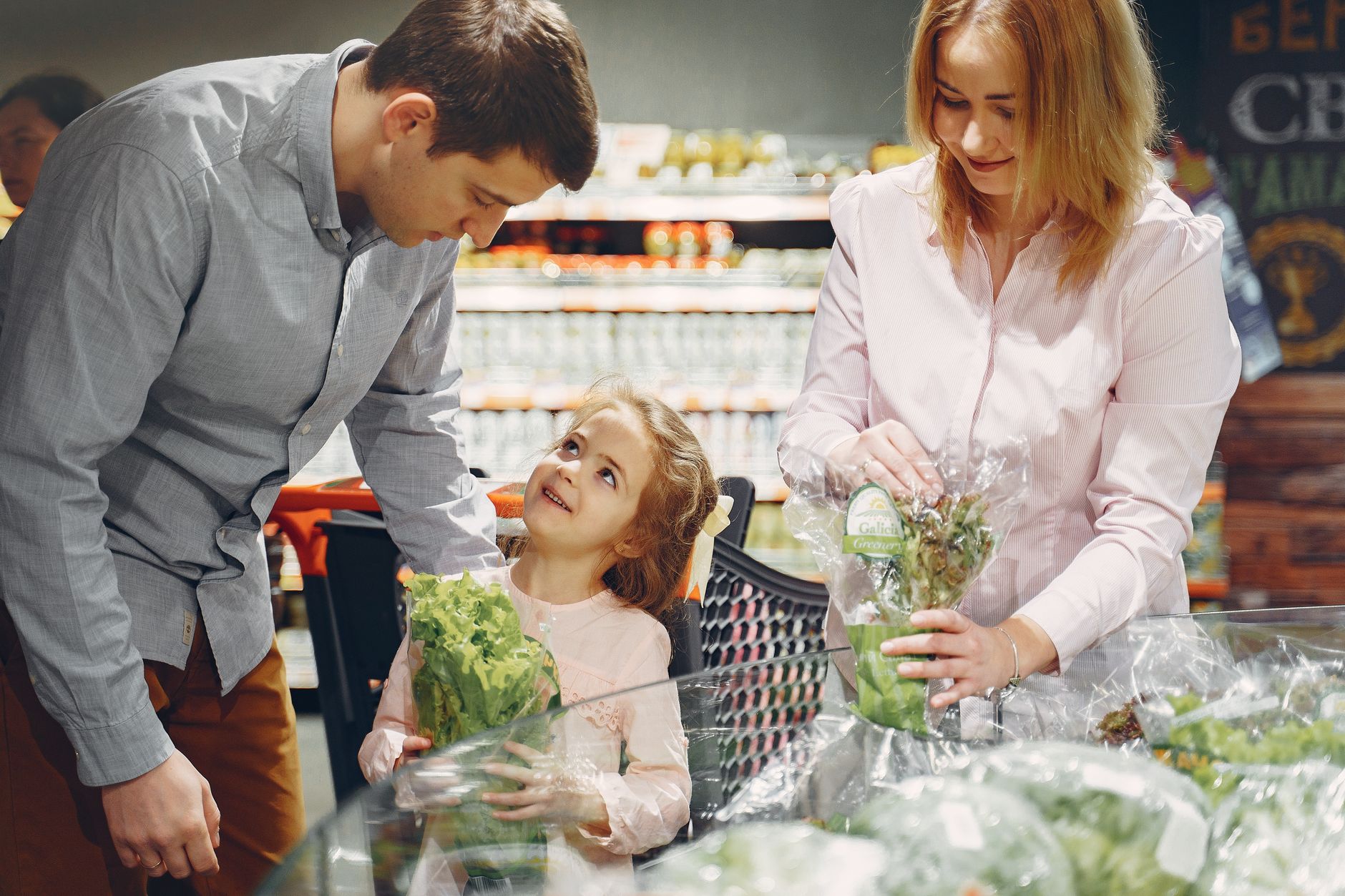 Family shopping for fresh vegetables at supermarket produce section